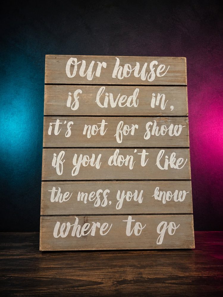 Rustic multi-plank Our House Is Lived In wooden quote sign.
