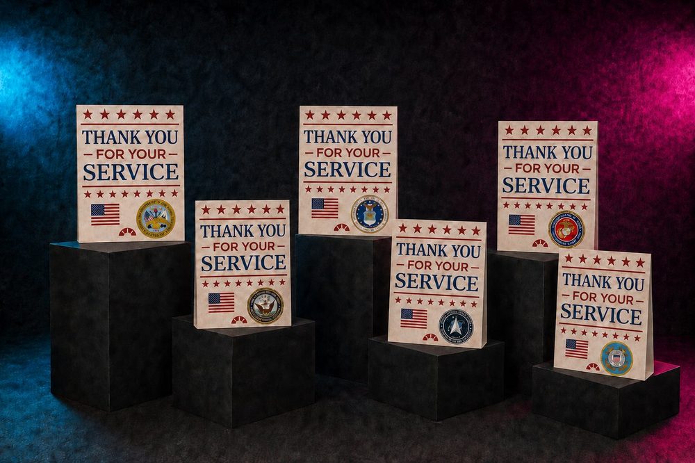 Six Thank You for Your Service cards, one for each U.S. military branch, displayed on black pedestals with blue and pink studio lighting.